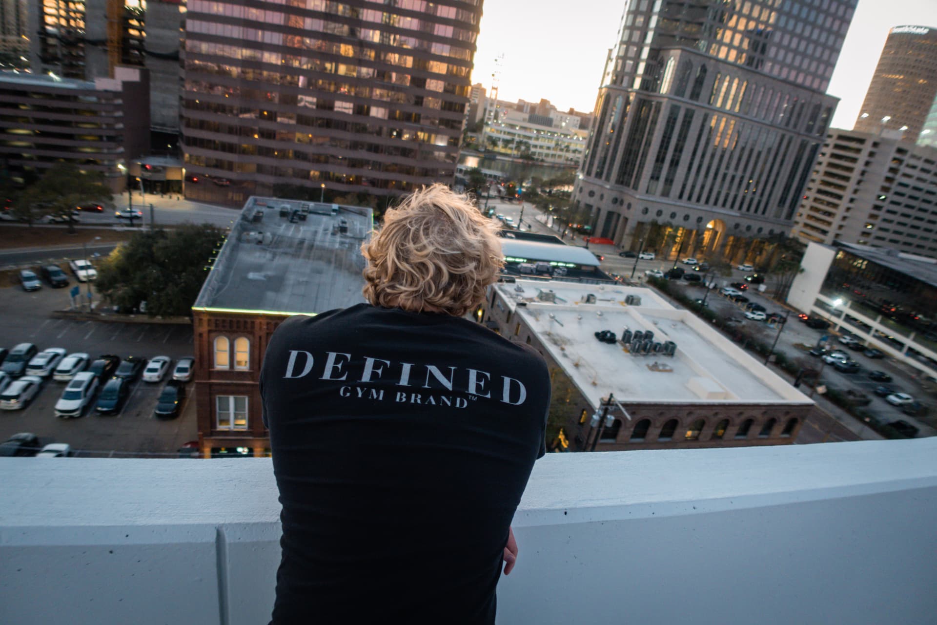 Model looking out over the city wearing a Defined Gym Brand back-print tee