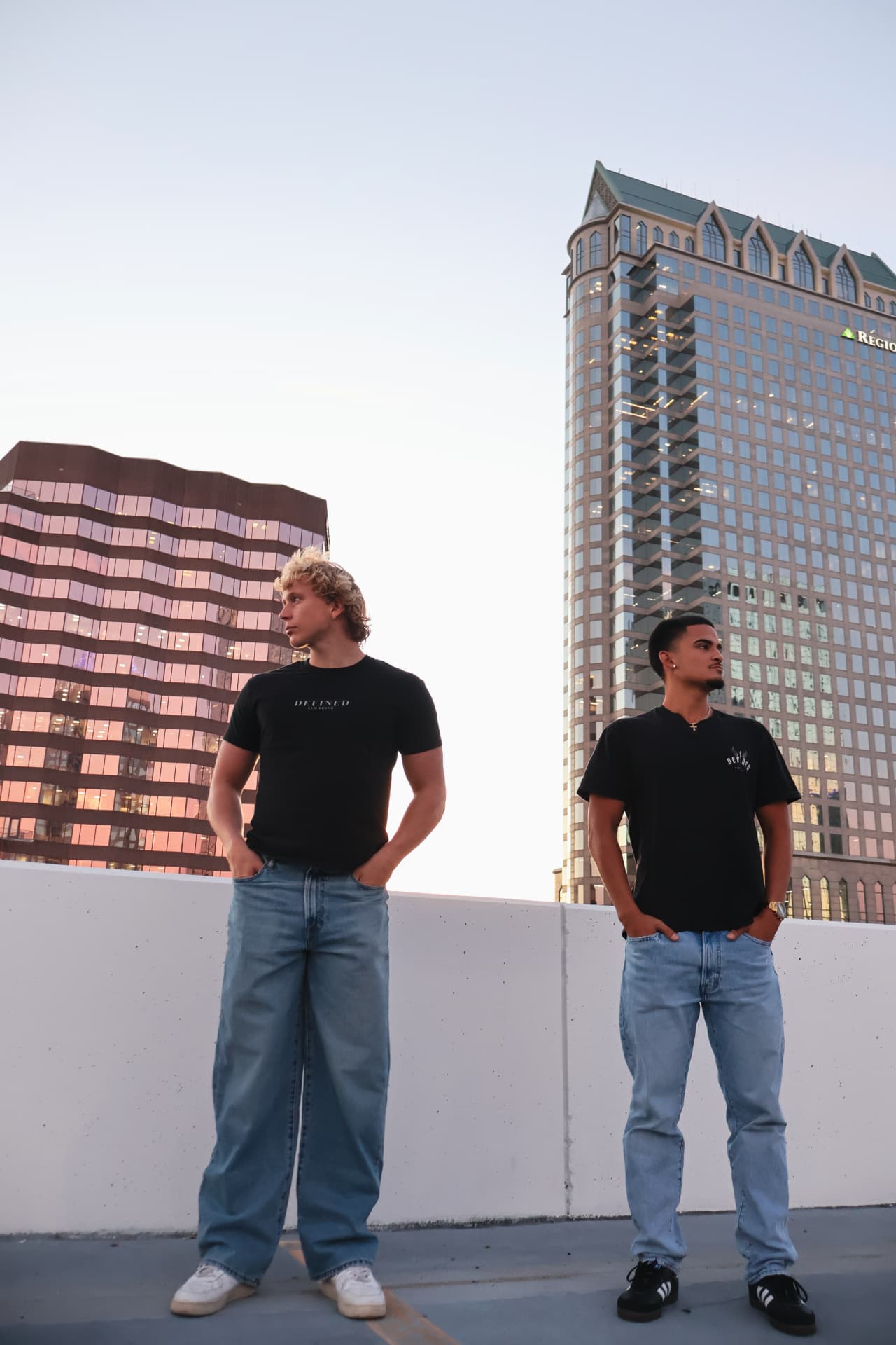 Two models standing on a downtown rooftop in Defined Gym Brand tees
